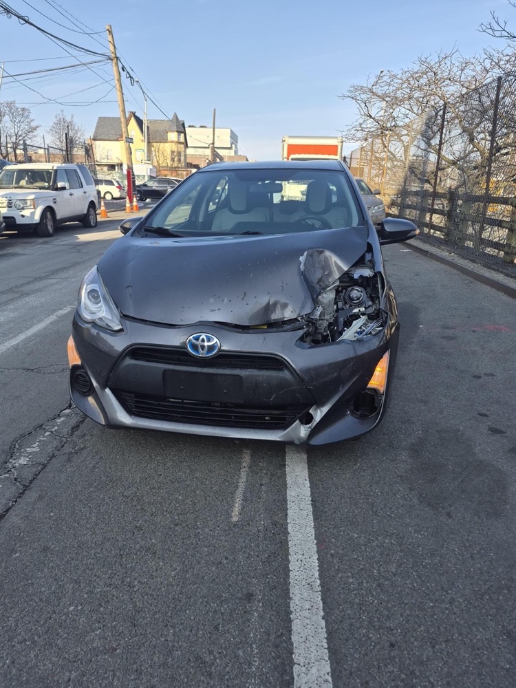 Before: Toyota Prius c with a crushed front bumper and headlight